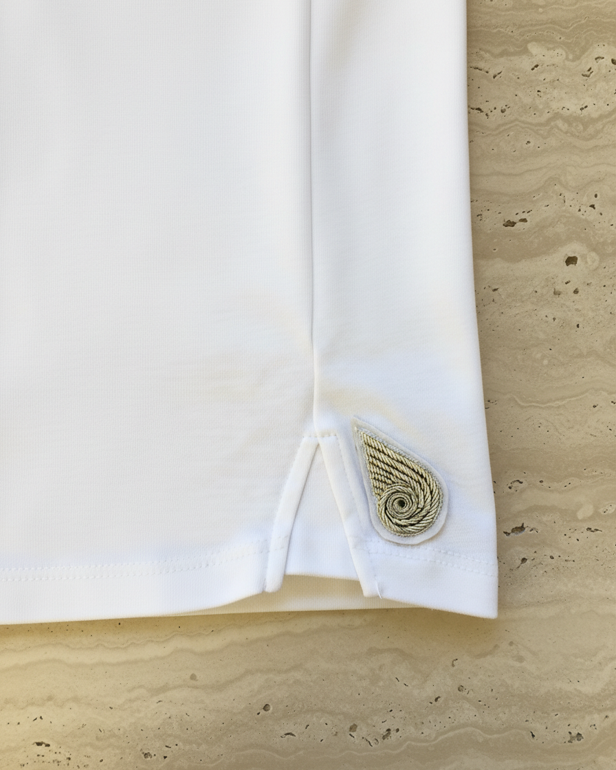 White tee with a decorative patch on limestone