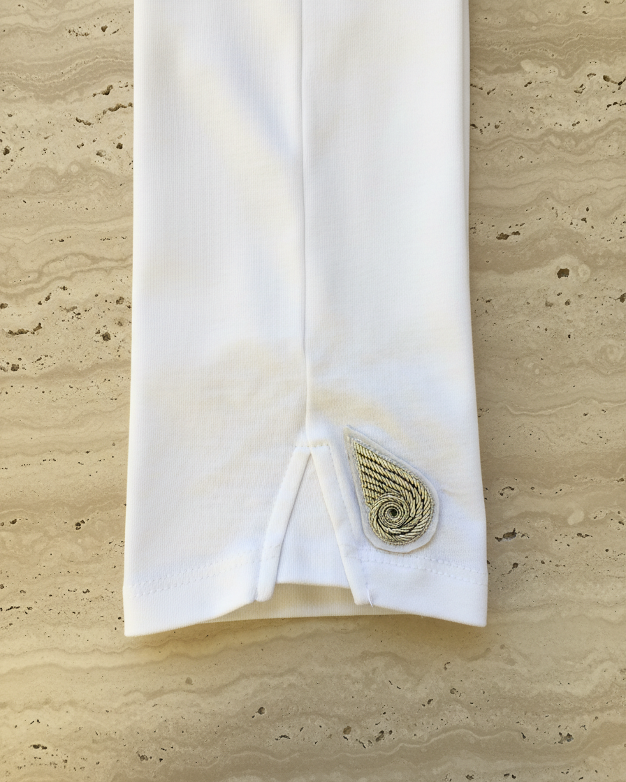 White tee with a decorative patch on limestone